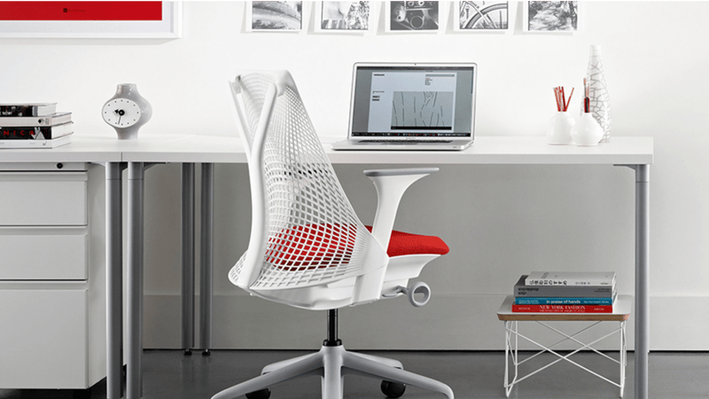 Modern home office with desk, chair, laptop, and framed pictures