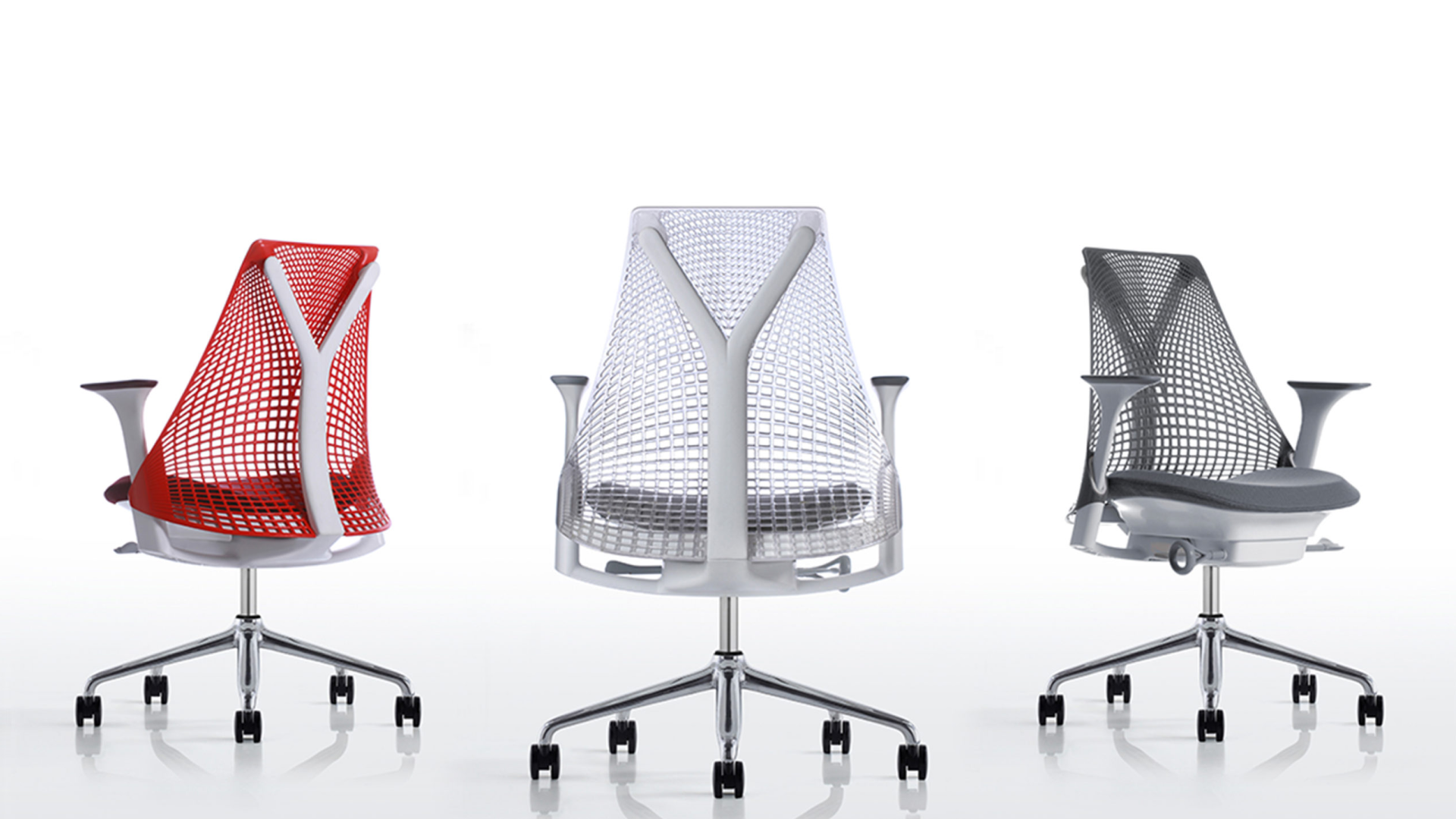 Three modern office chairs in red, white, and black against a neutral background.