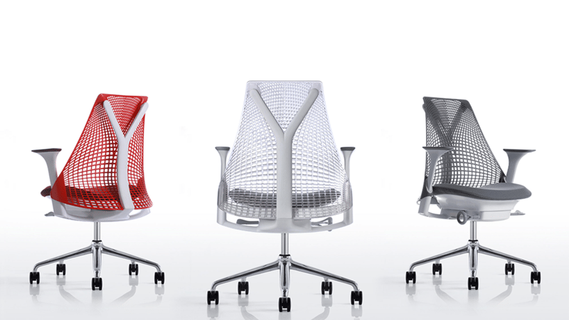 Three modern office chairs in red, white, and black against a neutral background.