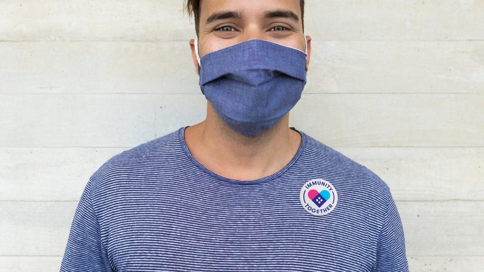 Immunity Together masked man wearing safety badge