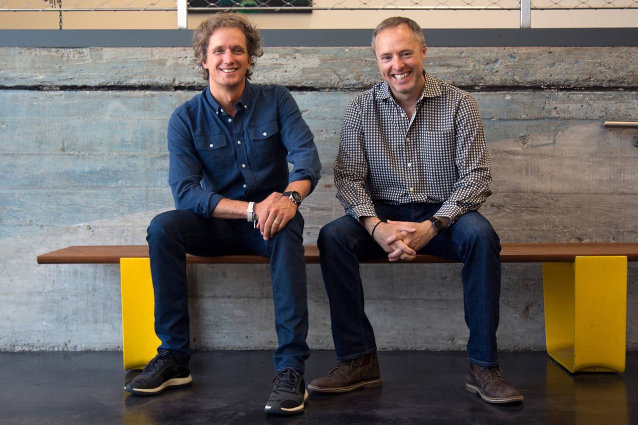 Two men sitting on yellow bench