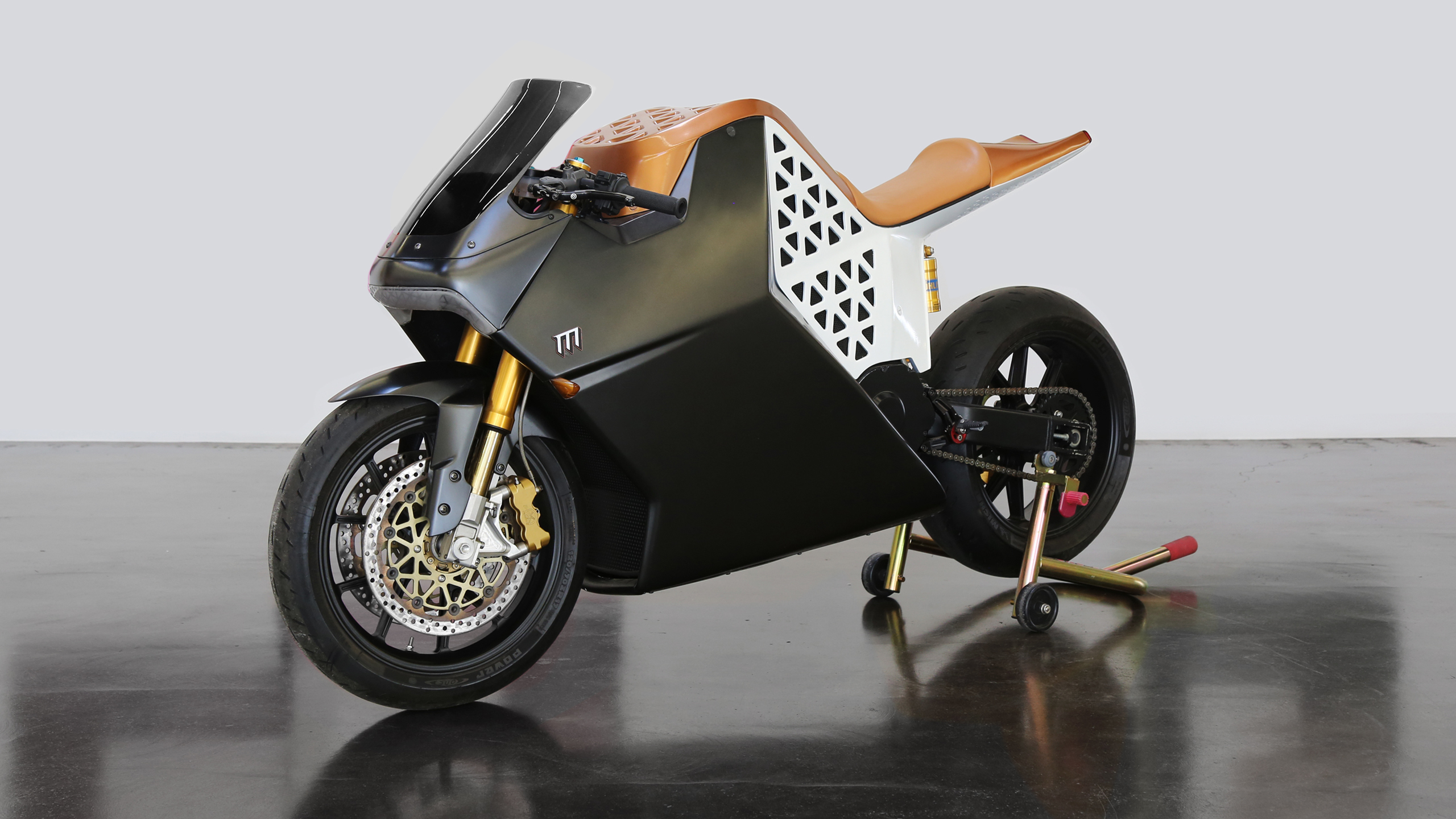 Mission Motors Black and white motorcycle with sleek bodywork on a concrete floor