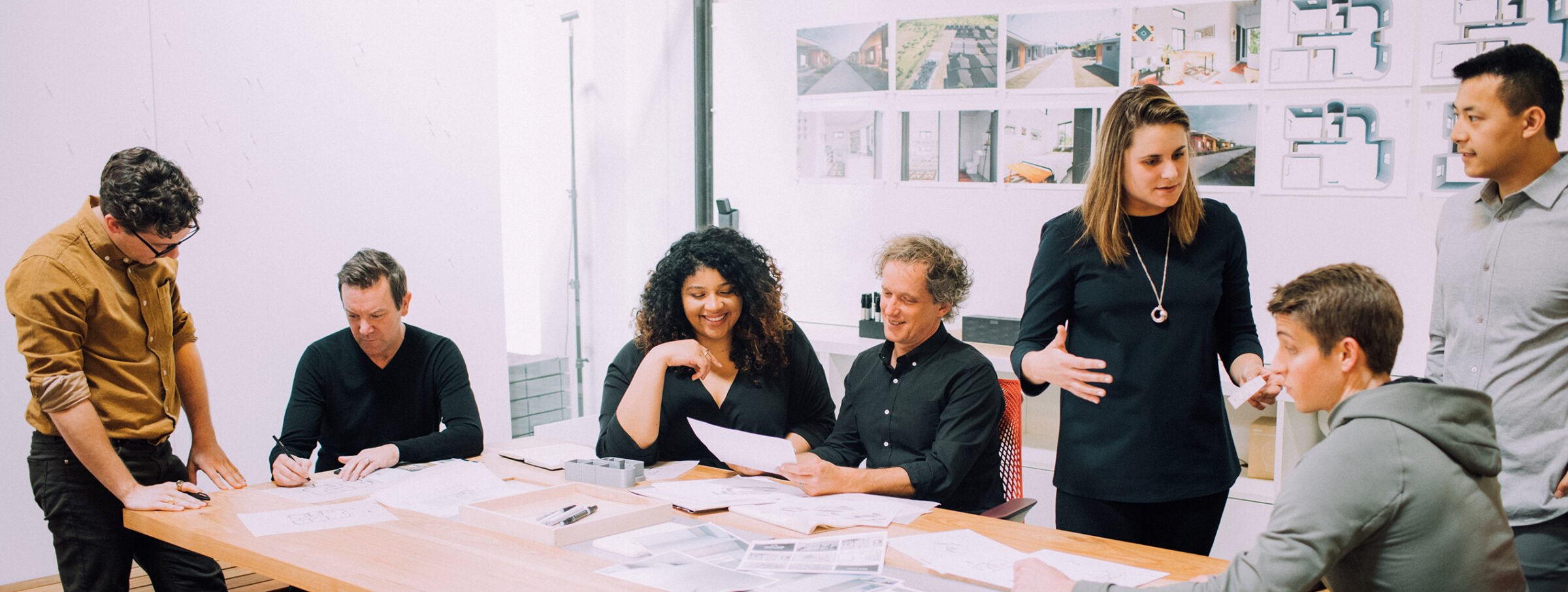 Group of people in a modern meeting room with white walls and natural light