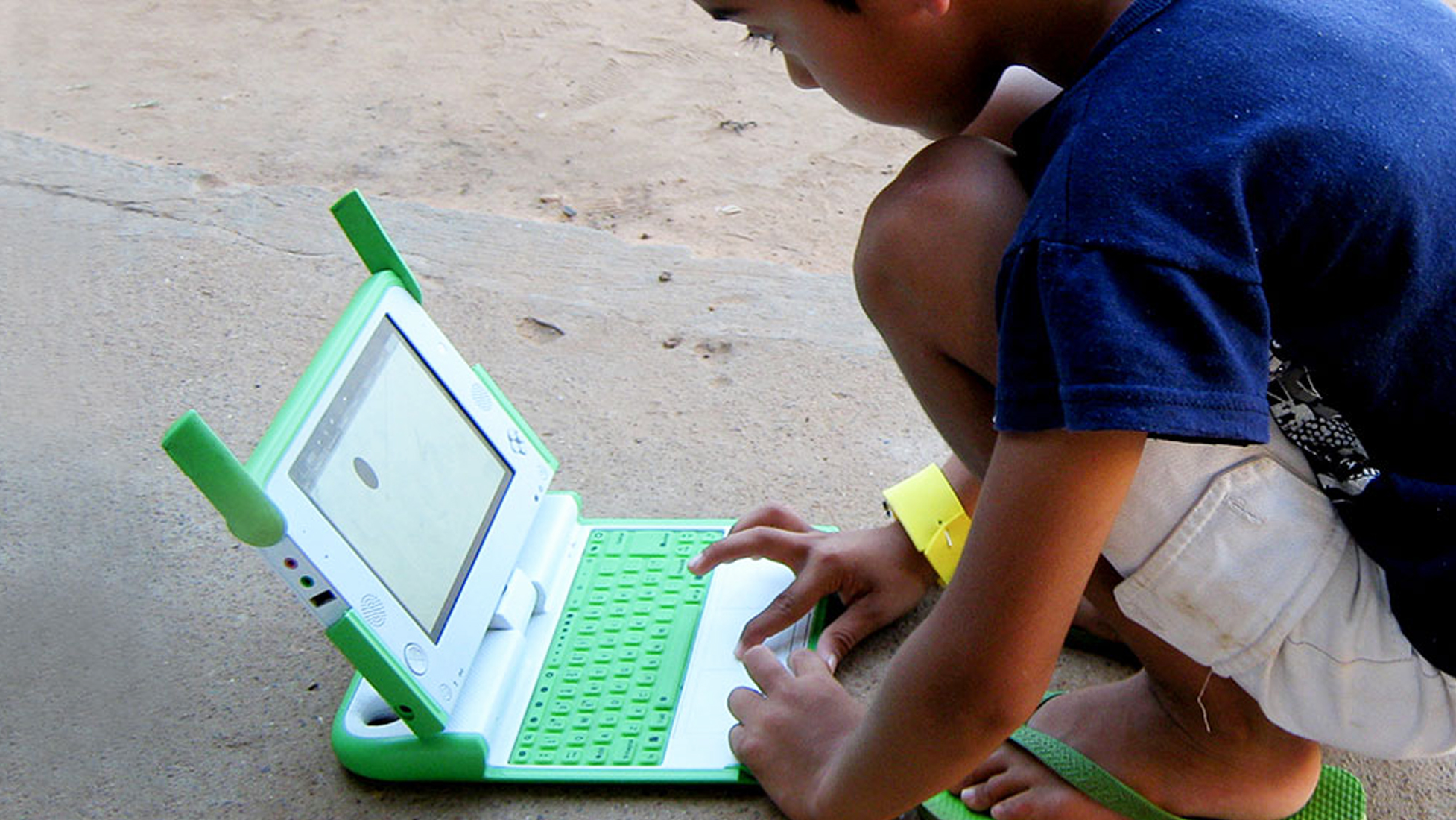 OLPC young boy using green laptop
