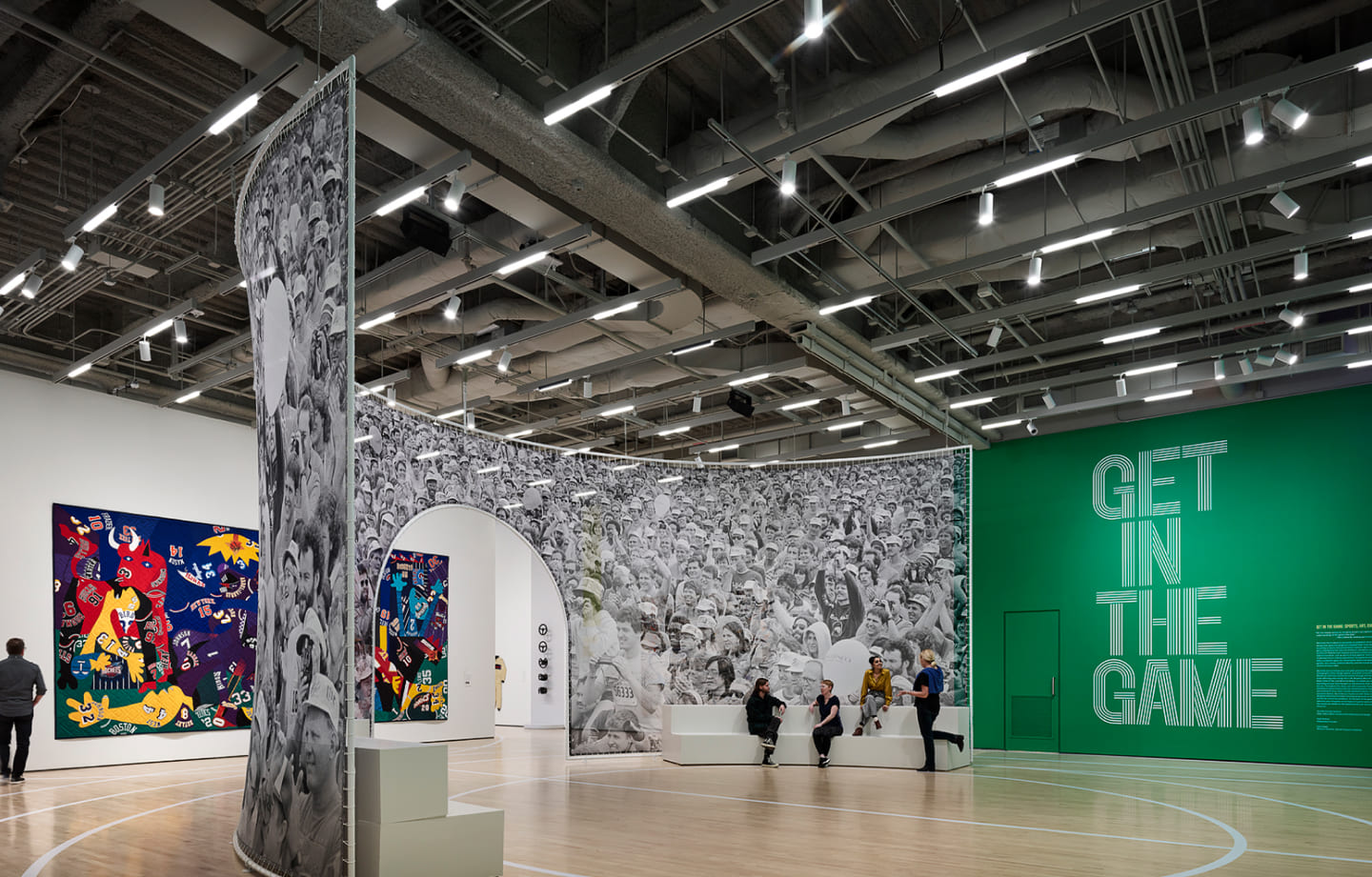 SFMOMA Get in the Game exhibition gallery with crowd photo mural archway, basketball court flooring and bold green wall typog