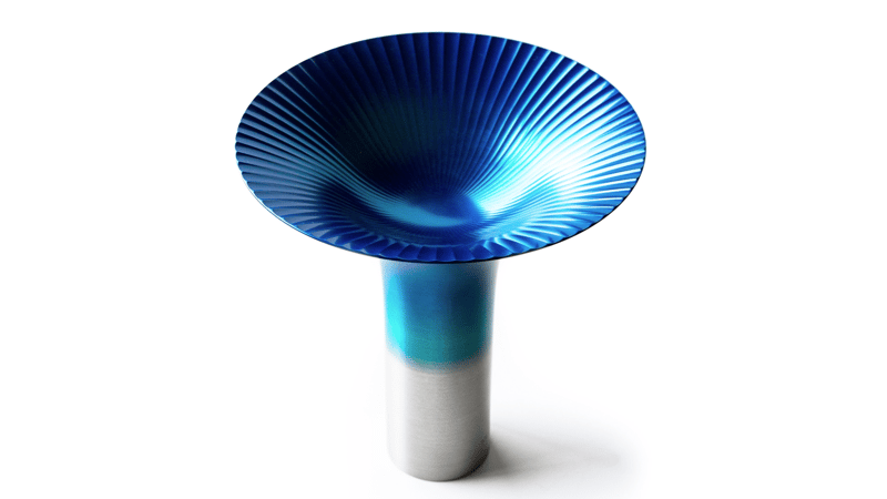 Blue and white abstract sculpture with metallic base on beige background