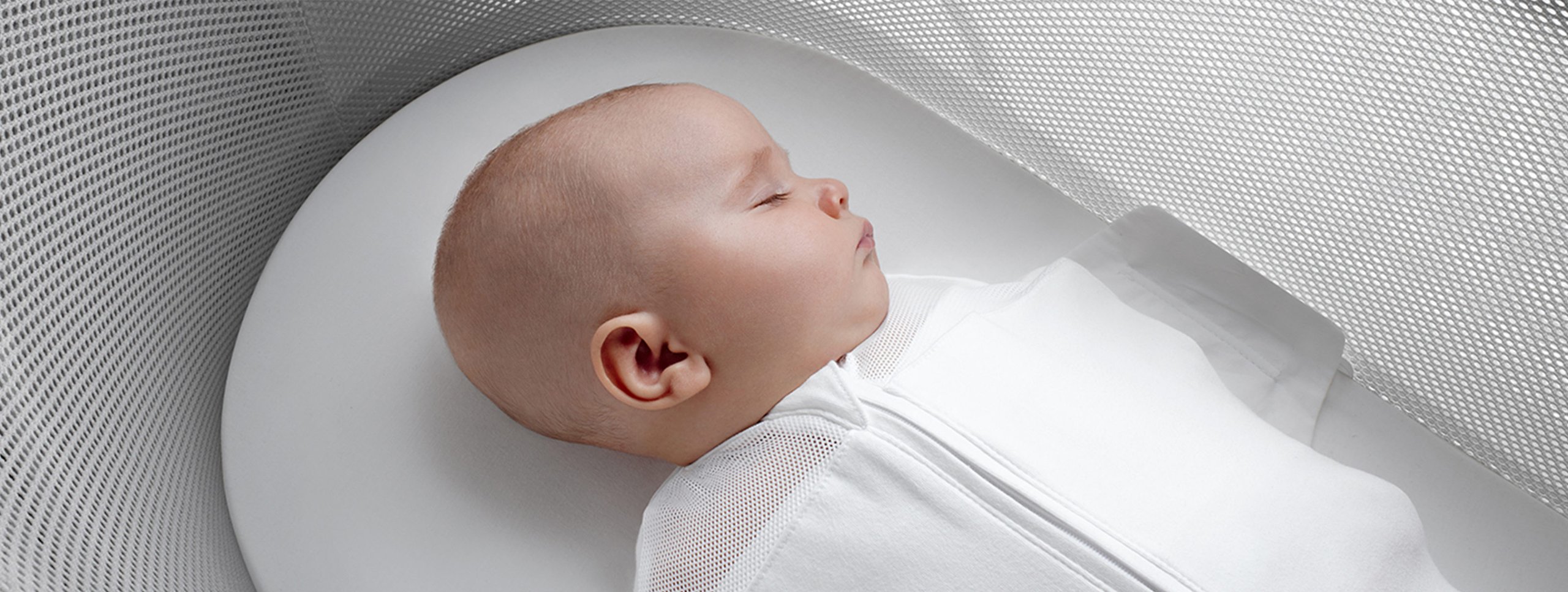 Snoo Smart Sleeper bassinet with sleeping infant