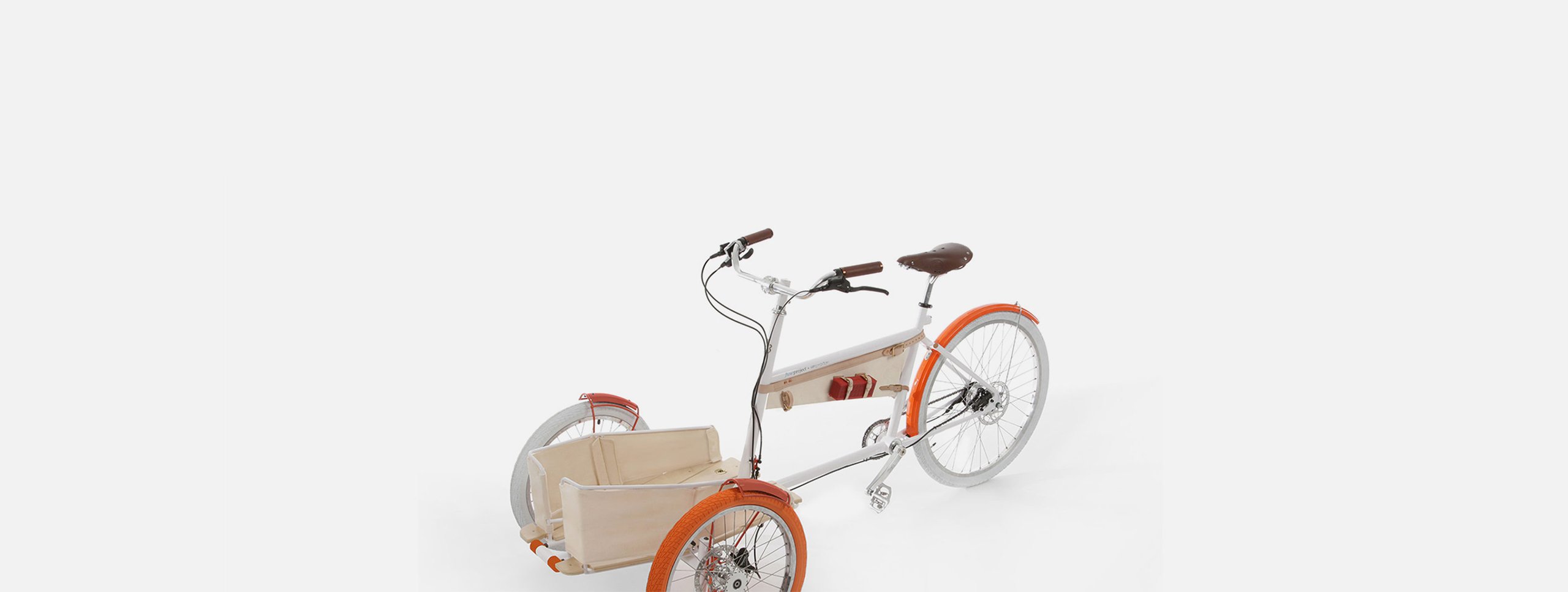 Local cargo tricycle with white frame, orange wheels, brown leather seat and grips, and a wooden front cargo crate