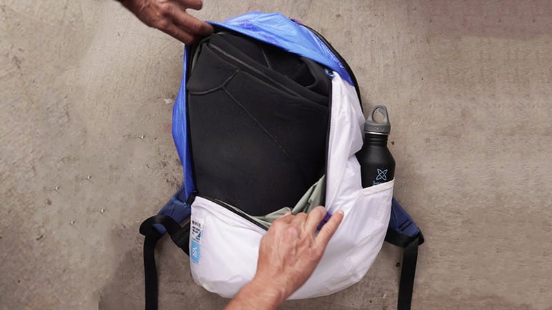 Deep Blue Bag person packing backpack outdoors