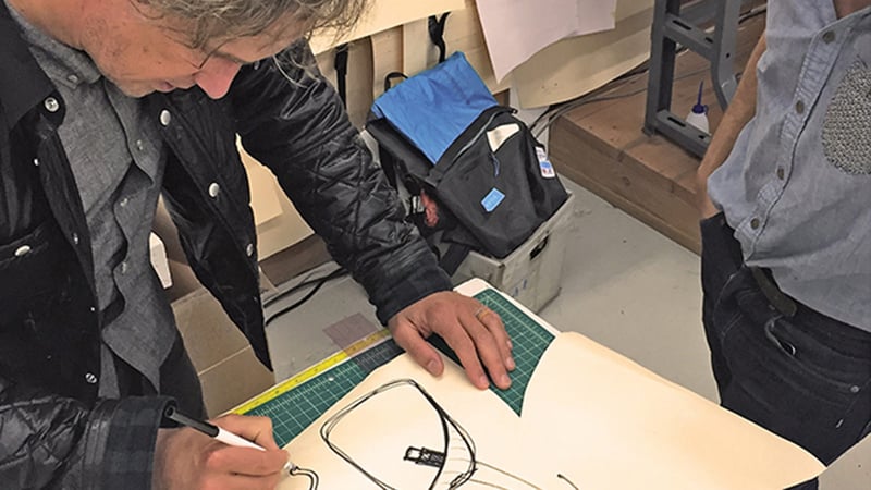 Craftsman writing in workshop with bag
