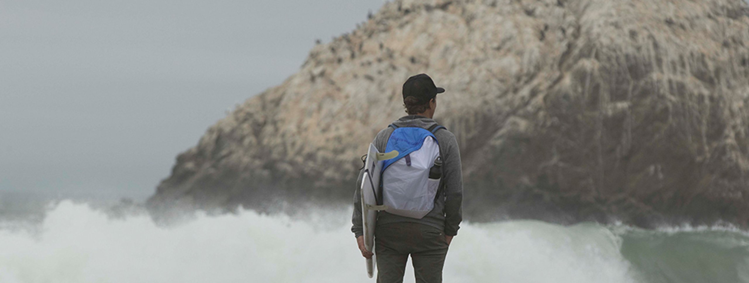 Deep Blue hiker with backpack on shore