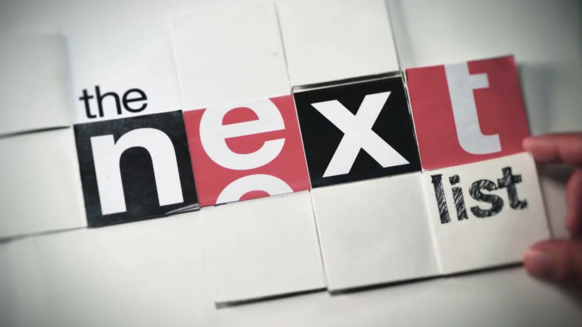 Hand holding block with NEXT inscribed, in a graphic style