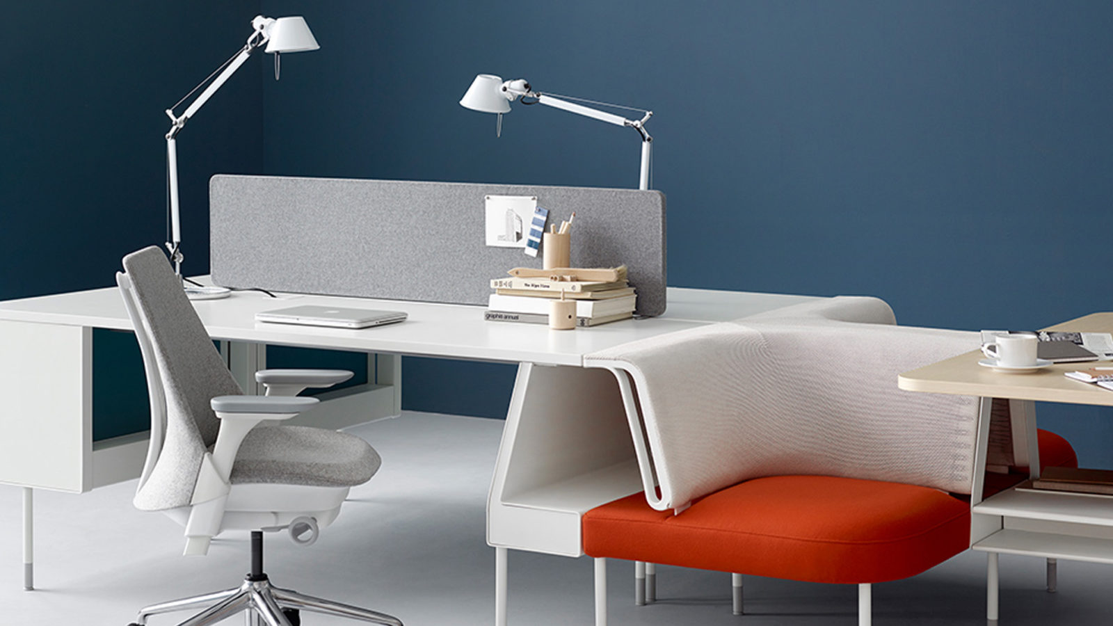 Modern office space with blue walls, white floor, and minimalist furniture
