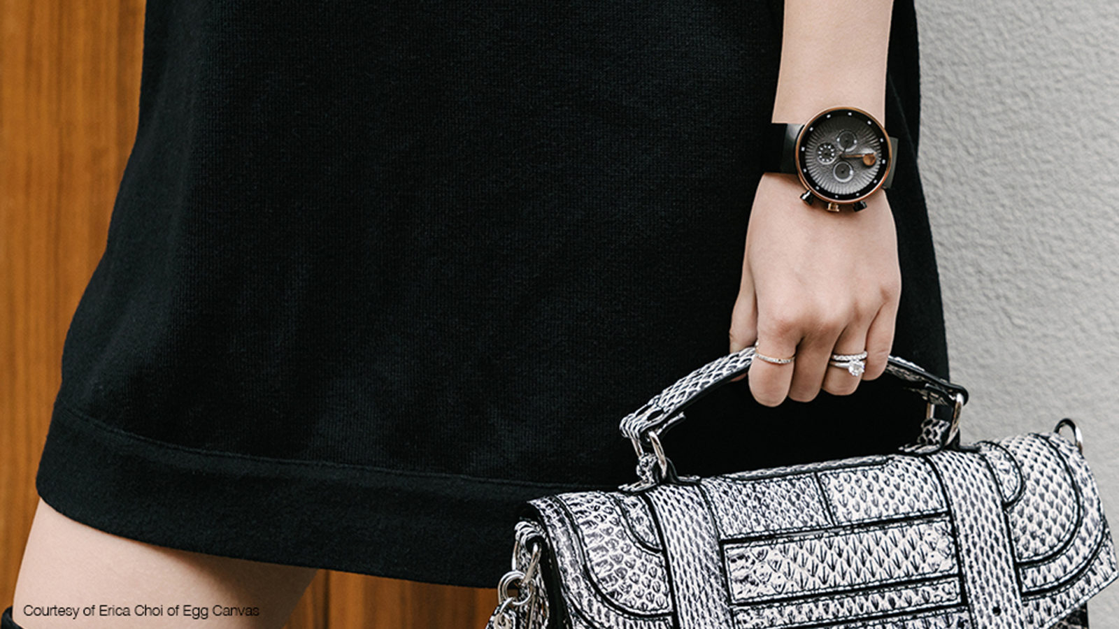 Woman holding Movado handbag in black