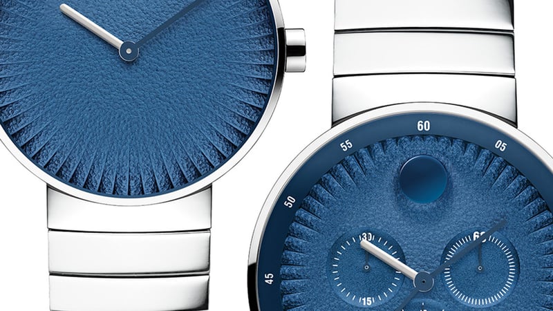 Three modern wristwatches with blue dials and white straps