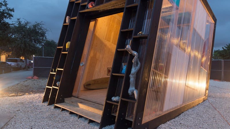 Small wooden structure with corrugated metal exterior at night
