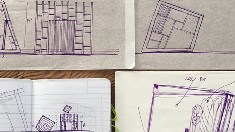 Black ink sketches of a building design on paper