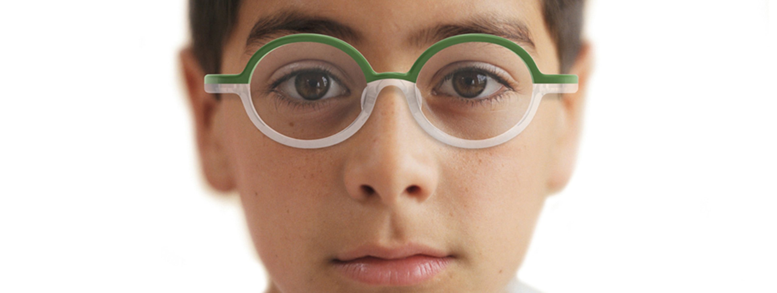 Child wearing green-framed glasses with a white bridge