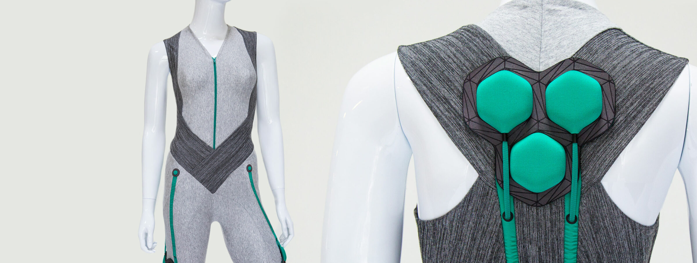 Two mannequins display a futuristic silver bodysuit with green accents