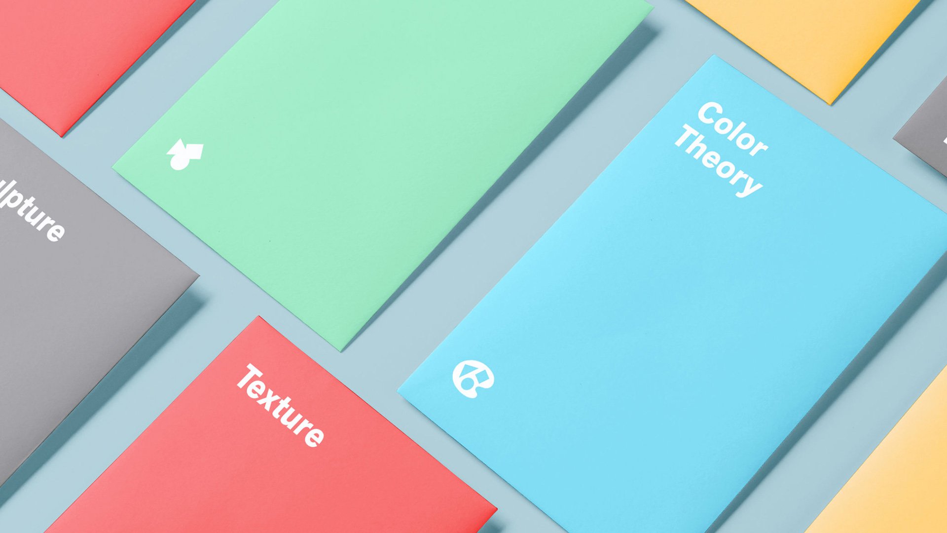 Six colorful notebooks with different themes on a light blue surface