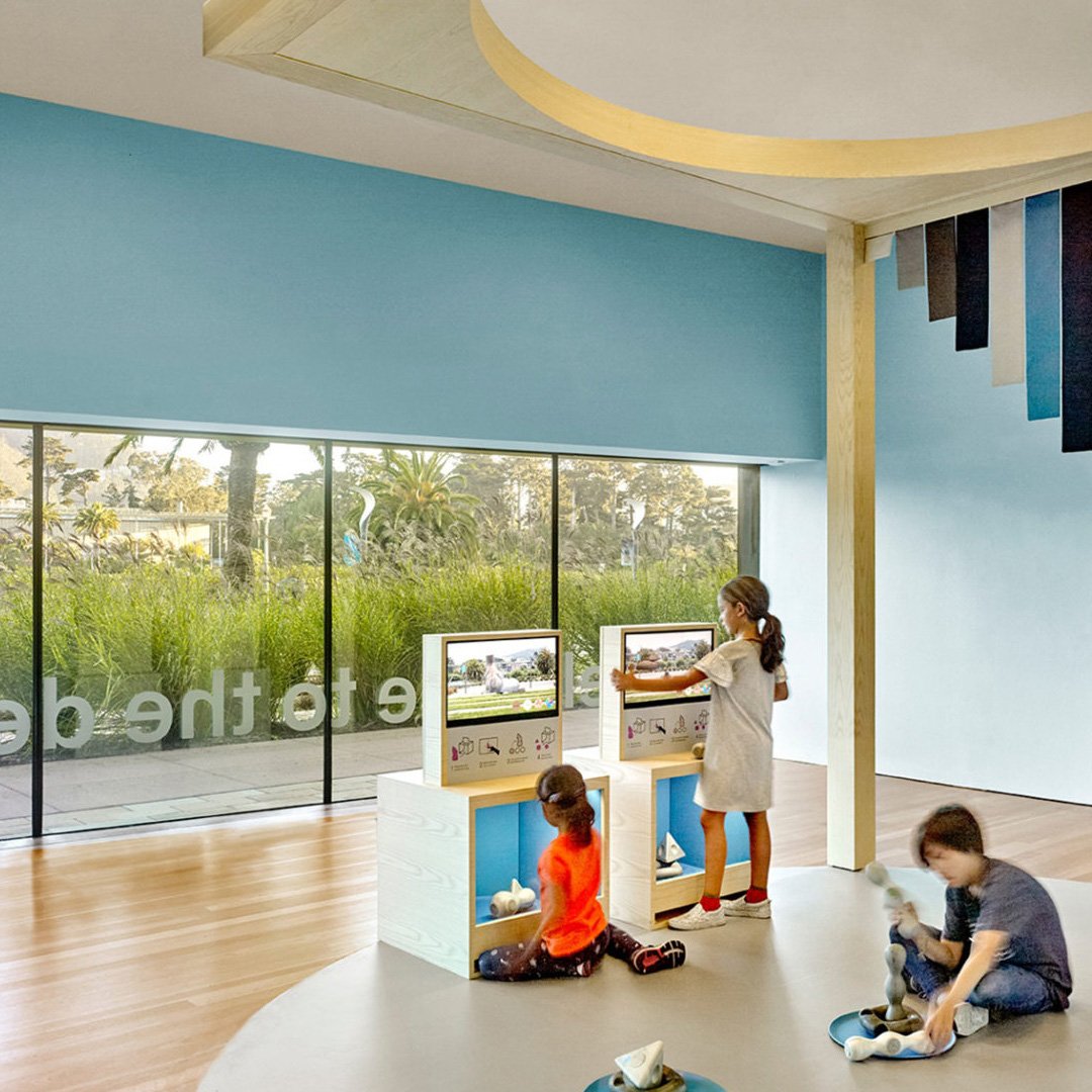 de Youngsters Studio: woman in white top standing at a podium with a window view in the background