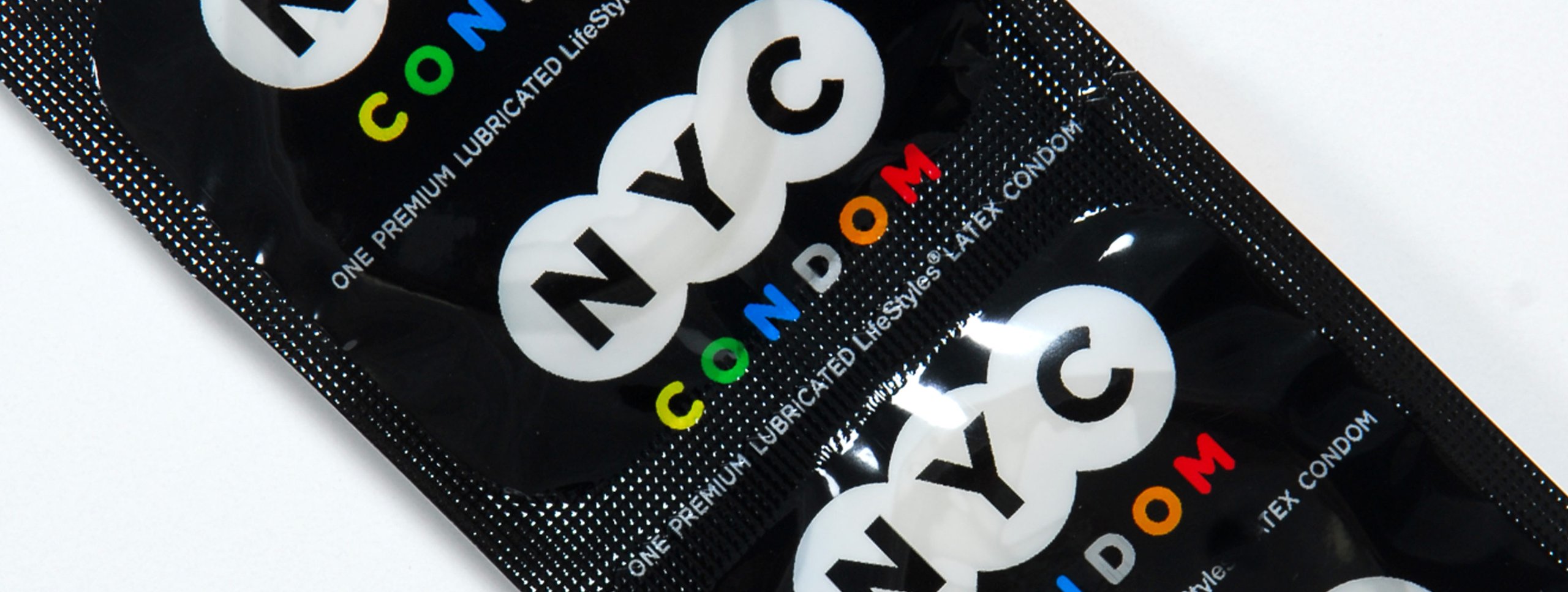 Black packages with NYC and CONDOM branding, colorful circular designs
