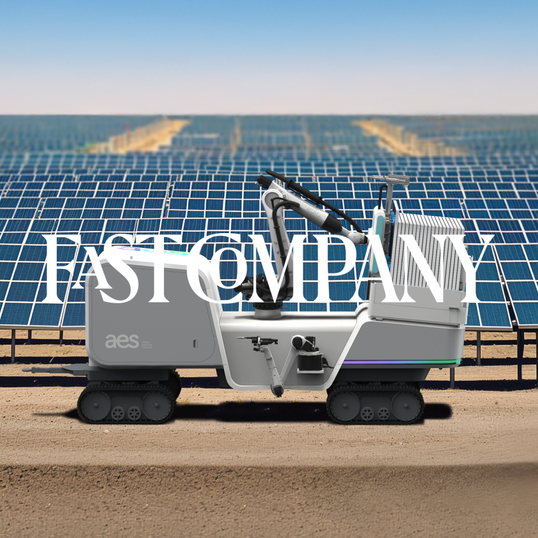 Electric vehicle with 'FAST COMPANY' text parked in front of solar farm