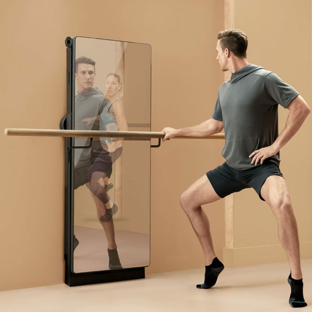 Man in sleeveless top and shorts standing in front of a mirror
