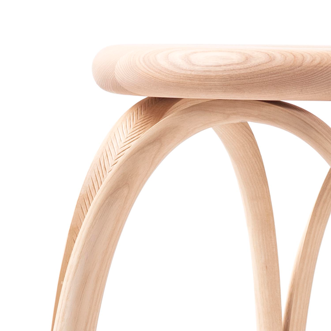 Wooden stool with curved top and wavy pattern on seat