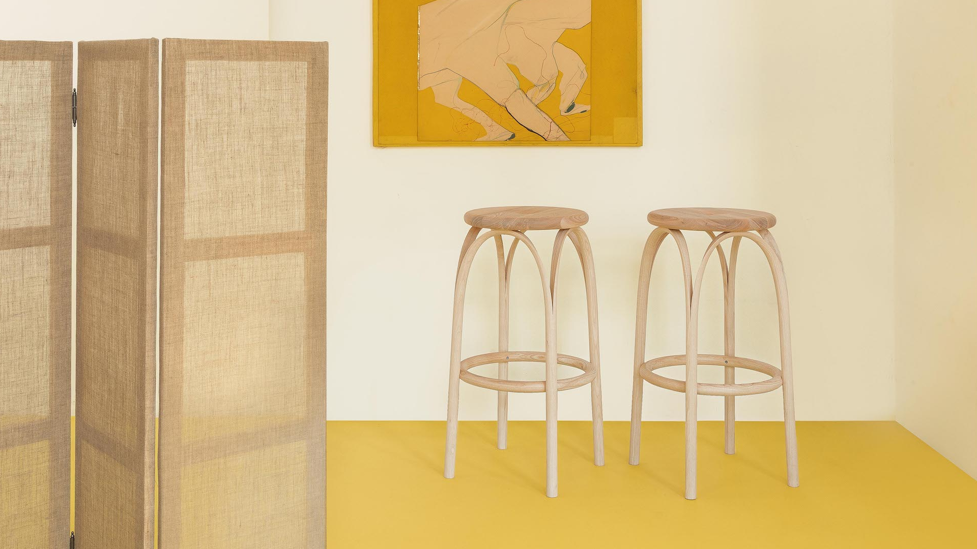 Yellow floor with three bar stools and beige countertop