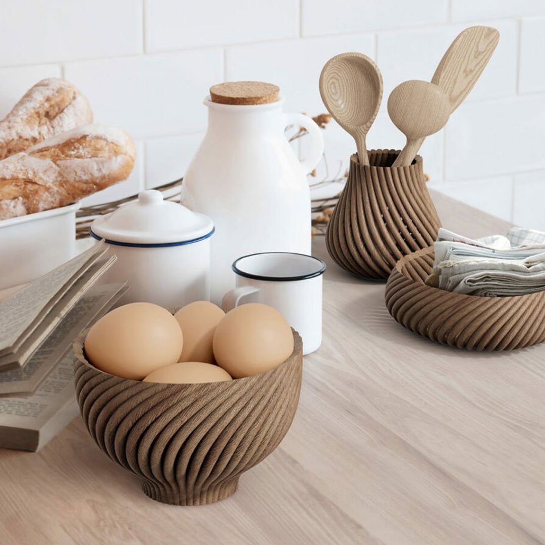 Forust 3D printed wooden utensils and bowls displayed on a white wall background