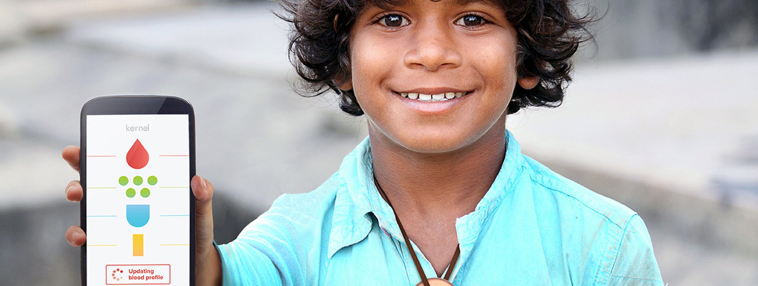 Kernal case study: smiling boy holding a smartphone displaying a heart and check mark health app interface