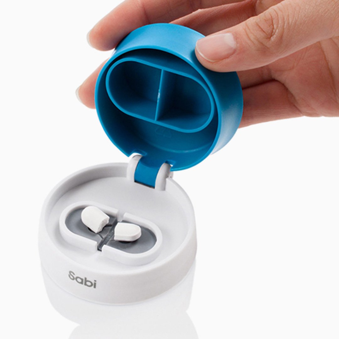 Blue pill container with two white pills on a white surface