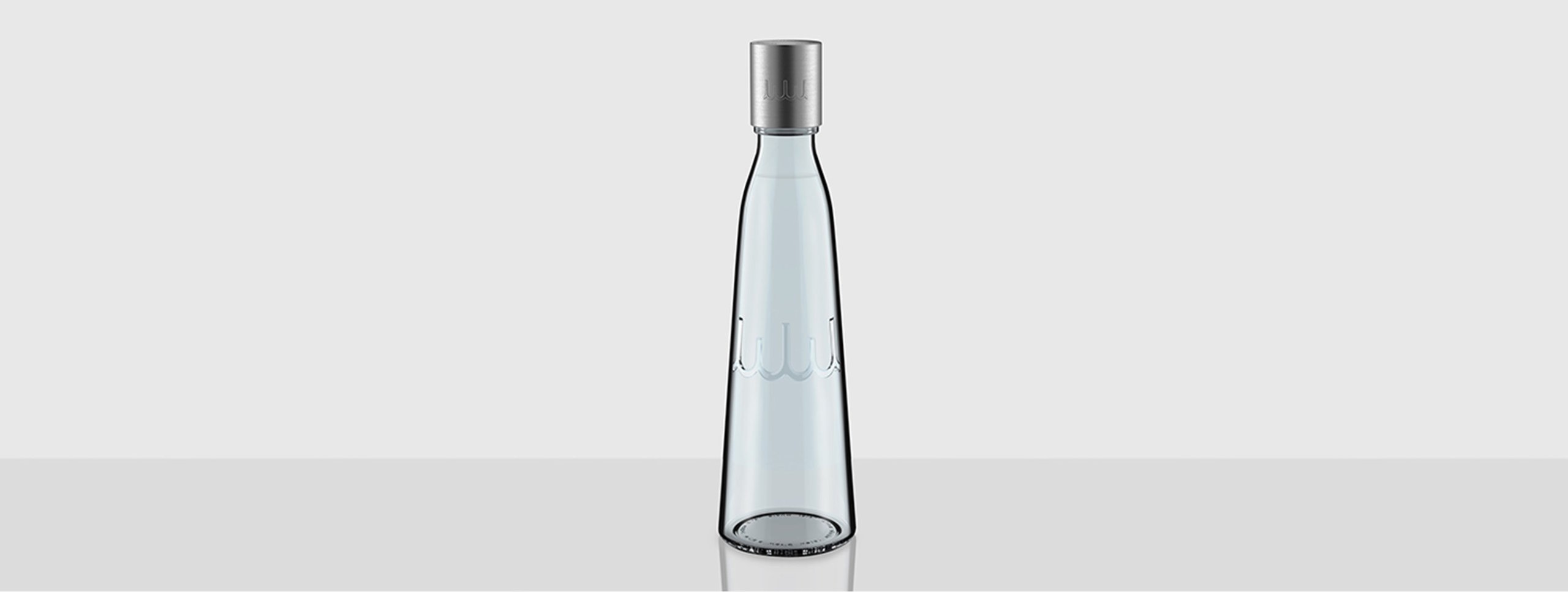 Whole World Water tapered clear glass bottle with brushed metal cap and embossed WWW logo at the base.