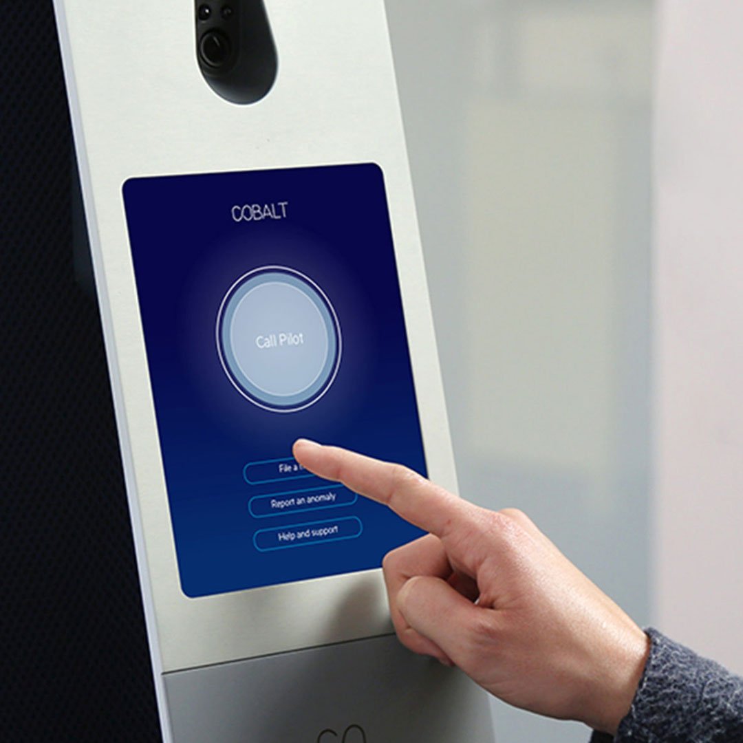 Person interacting with a blue touch-screen kiosk