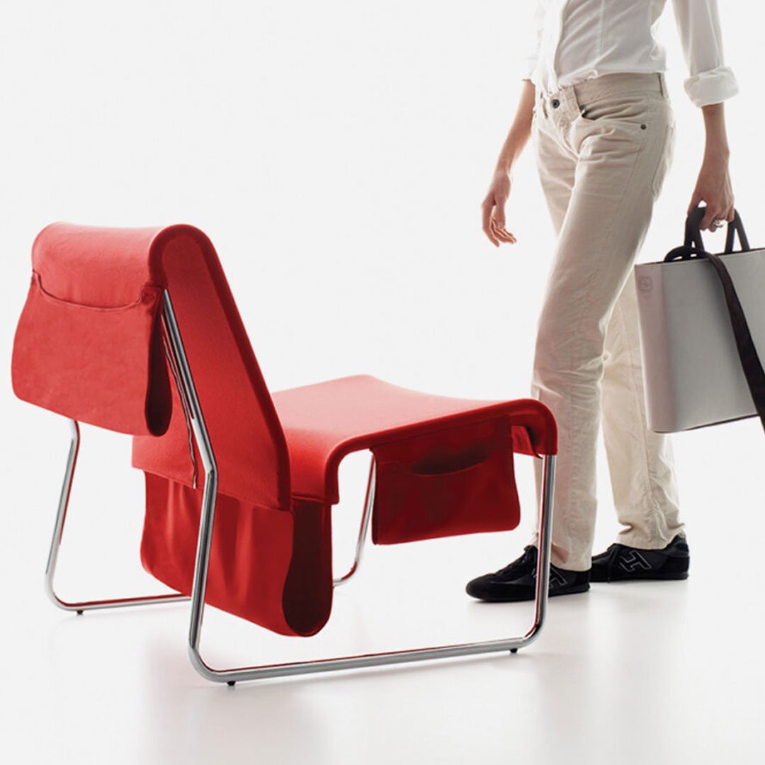 Woman standing by Danese Kada Farallon red chairs