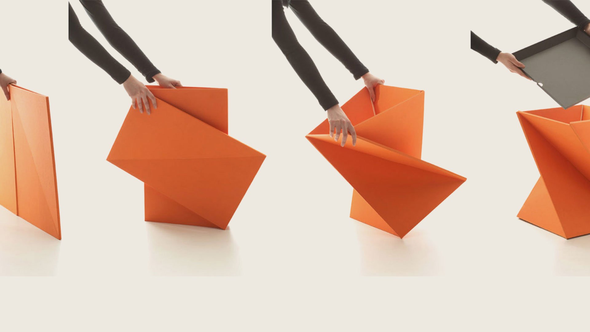 Orange origami figure in four stages of folding on a plain white background