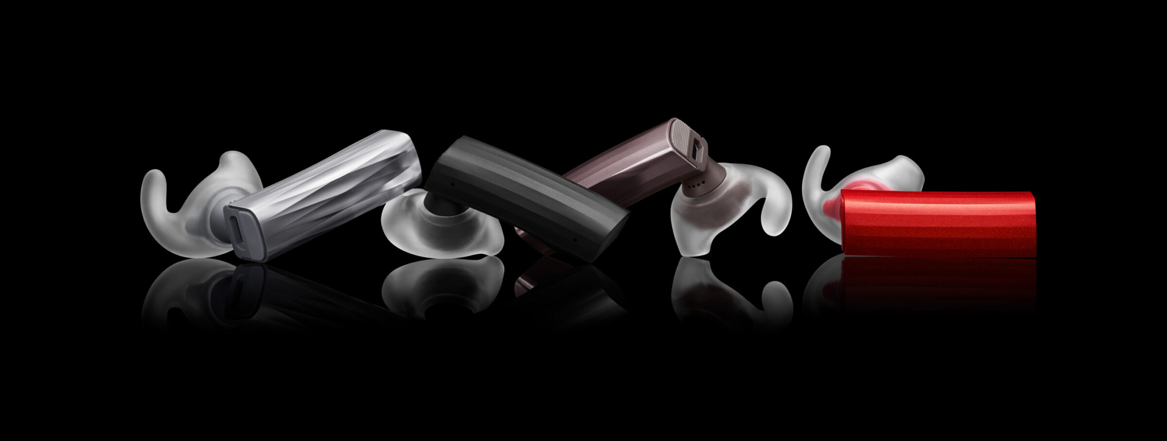 Jawbone Era earbuds in red, black and white arranged on a dark reflective background