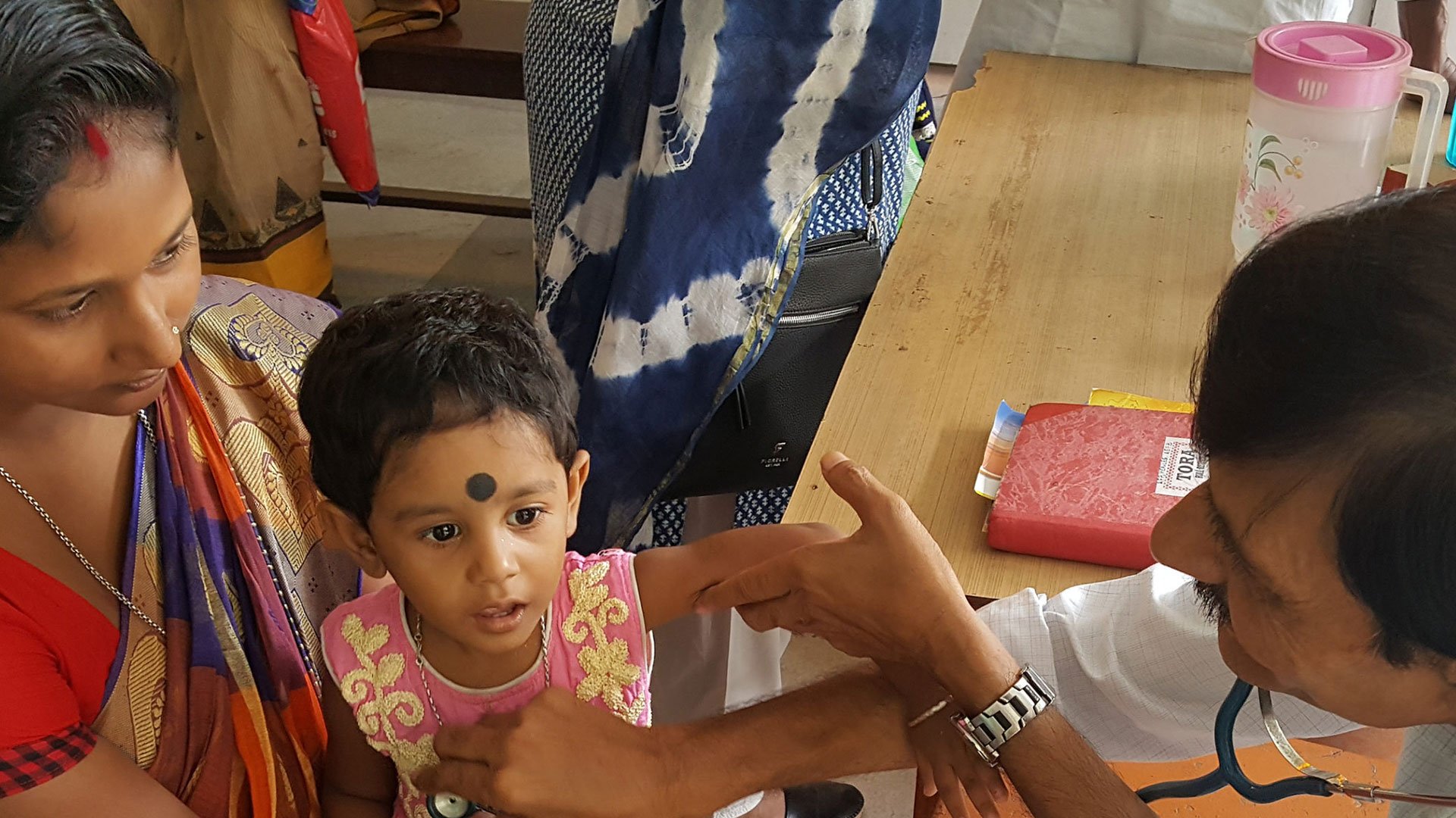 GE Healthcare diagnostics: adult comforting a young child during a medical visit