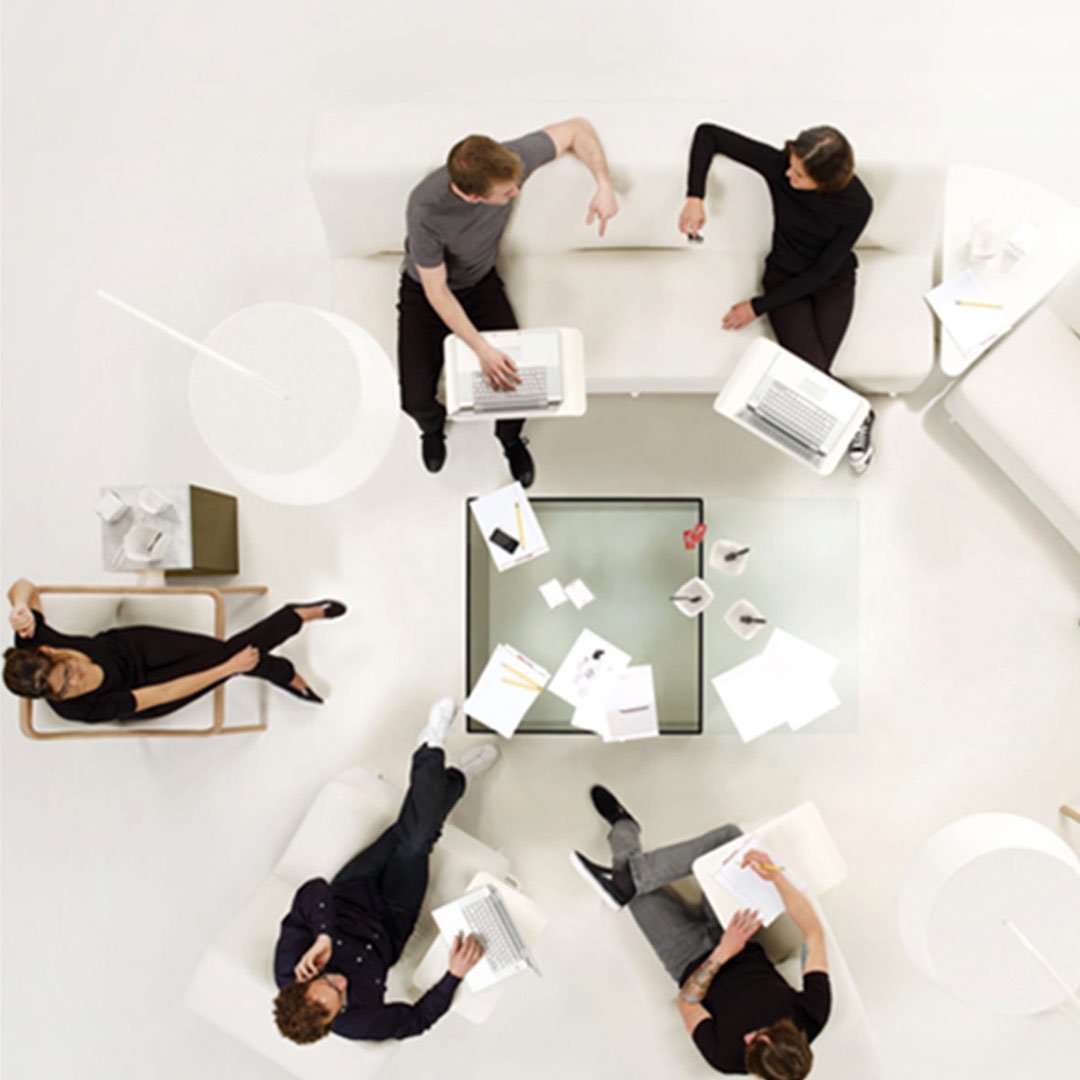 HBF six people meeting around a circular table in a minimalist office workspace