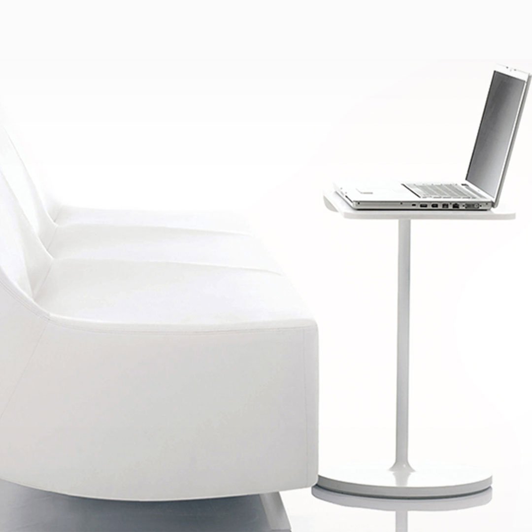 HBF minimalist white and gray living scene with sleek laptop on a small side table beside a sofa chair