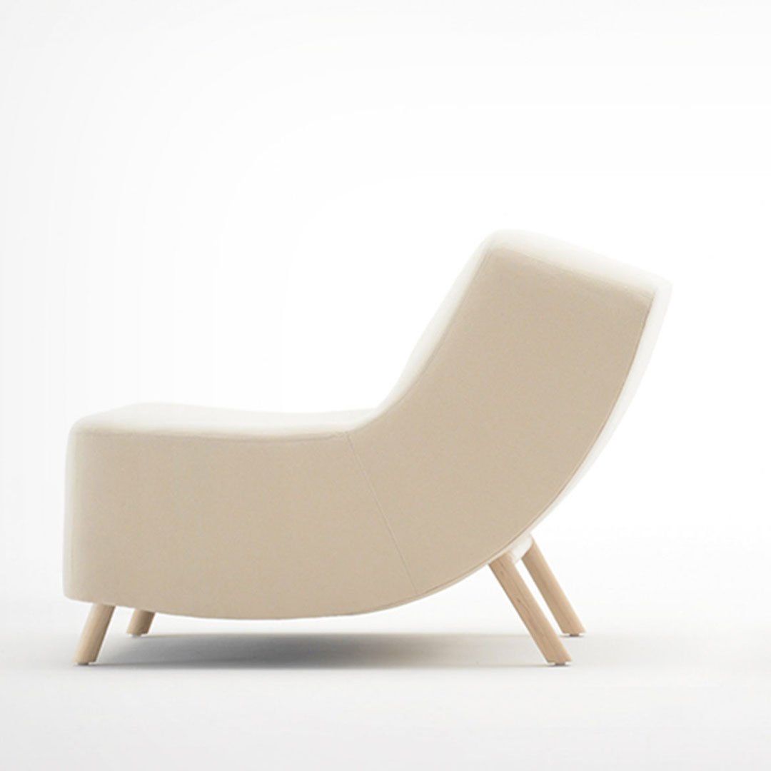 Beige armchair on light-colored floor against a white background