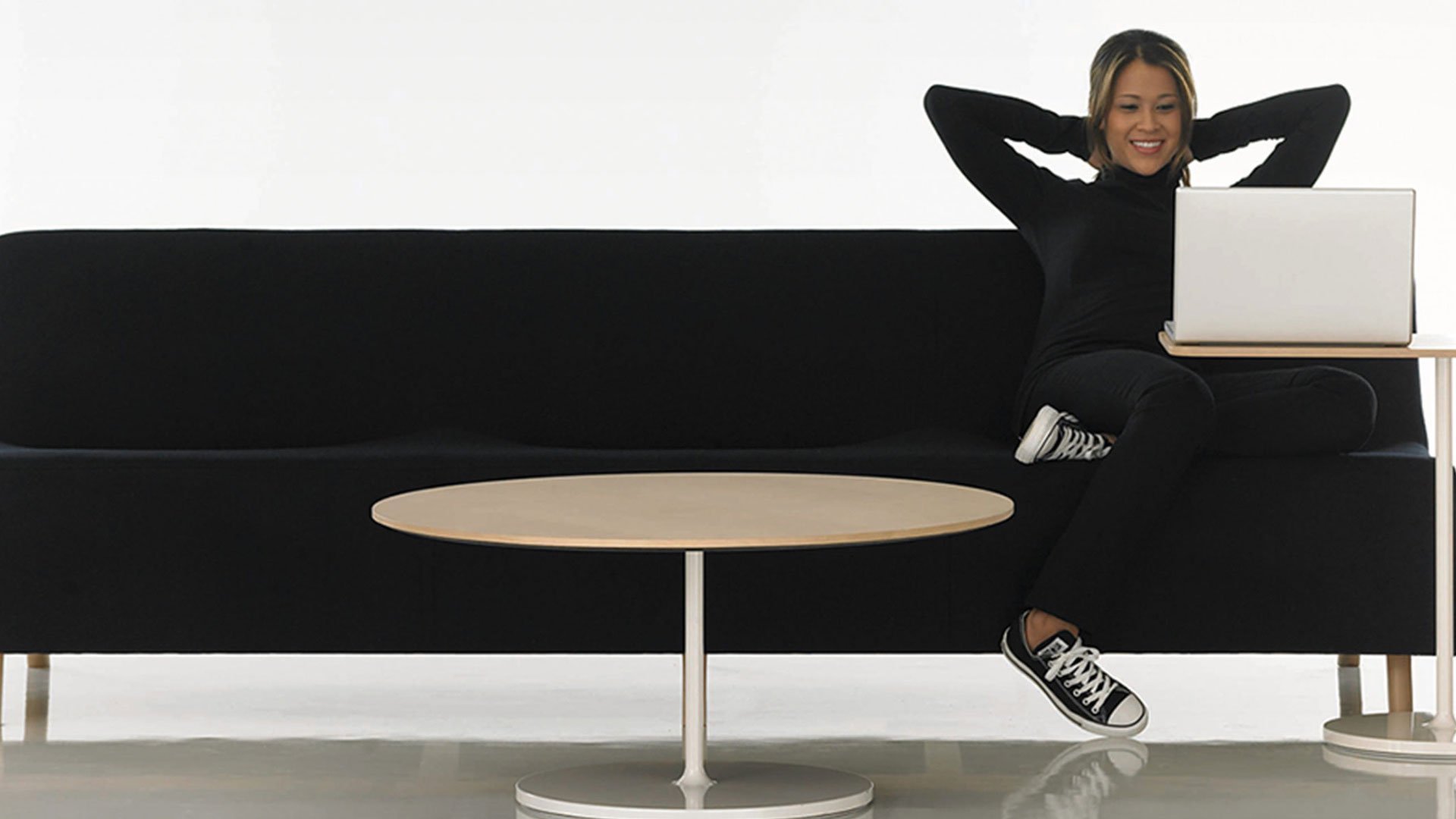 HBF stylized retro image of a person reclining on a black couch with a laptop