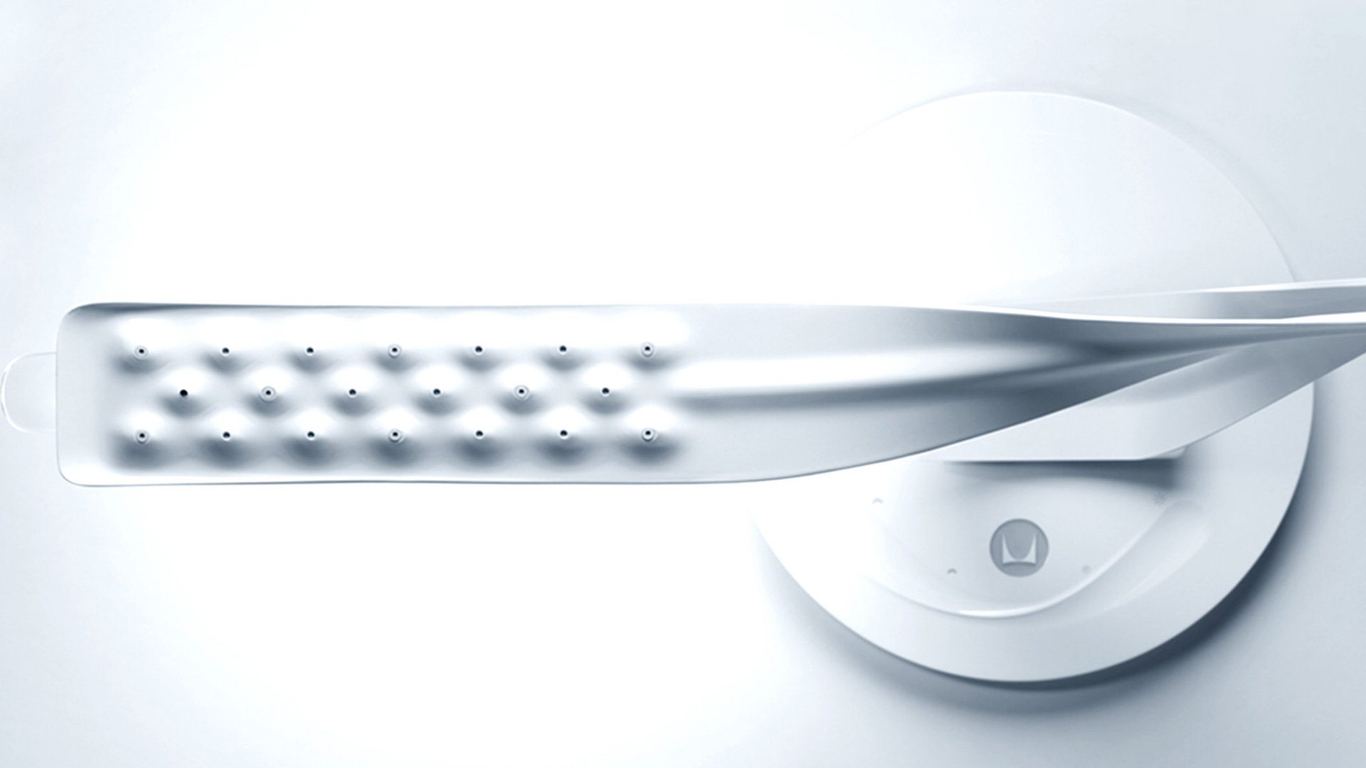 Silver scissors with blades cutting through a white surface