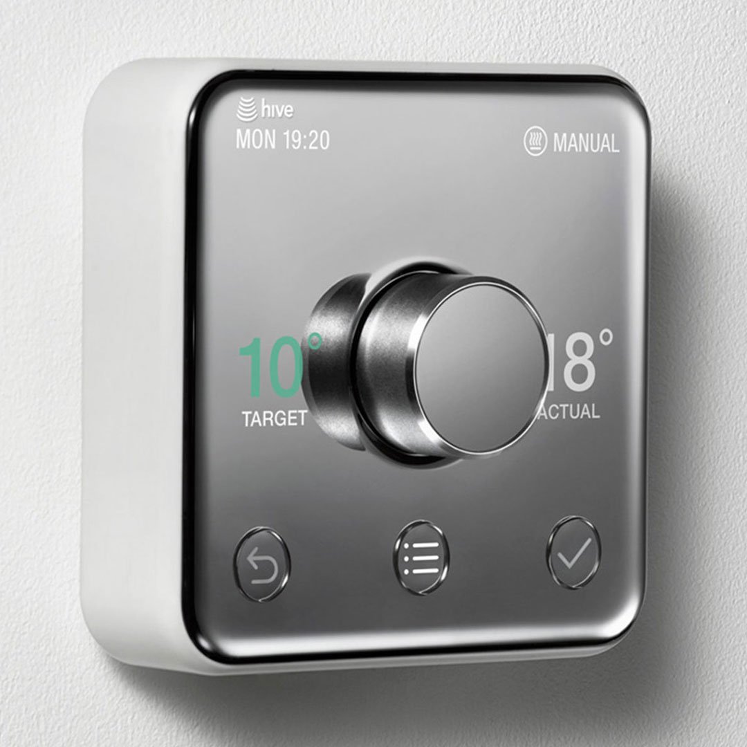Silver thermostat with digital display and black controls mounted on a wall
