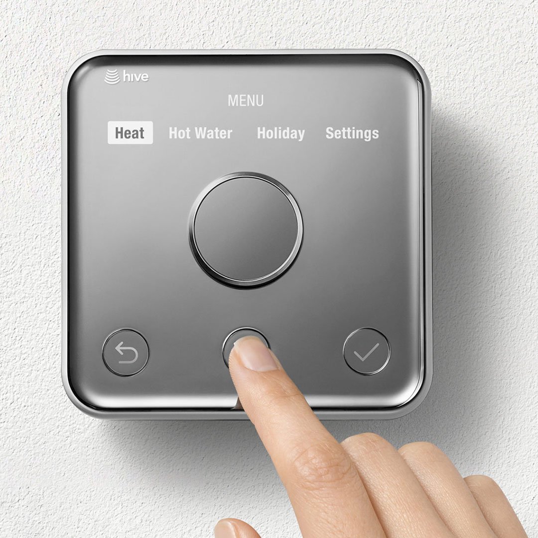 Hive Active Heating smart thermostat by Yves Béhar, a chrome-framed wall-mounted control with circular dial and finger pressi