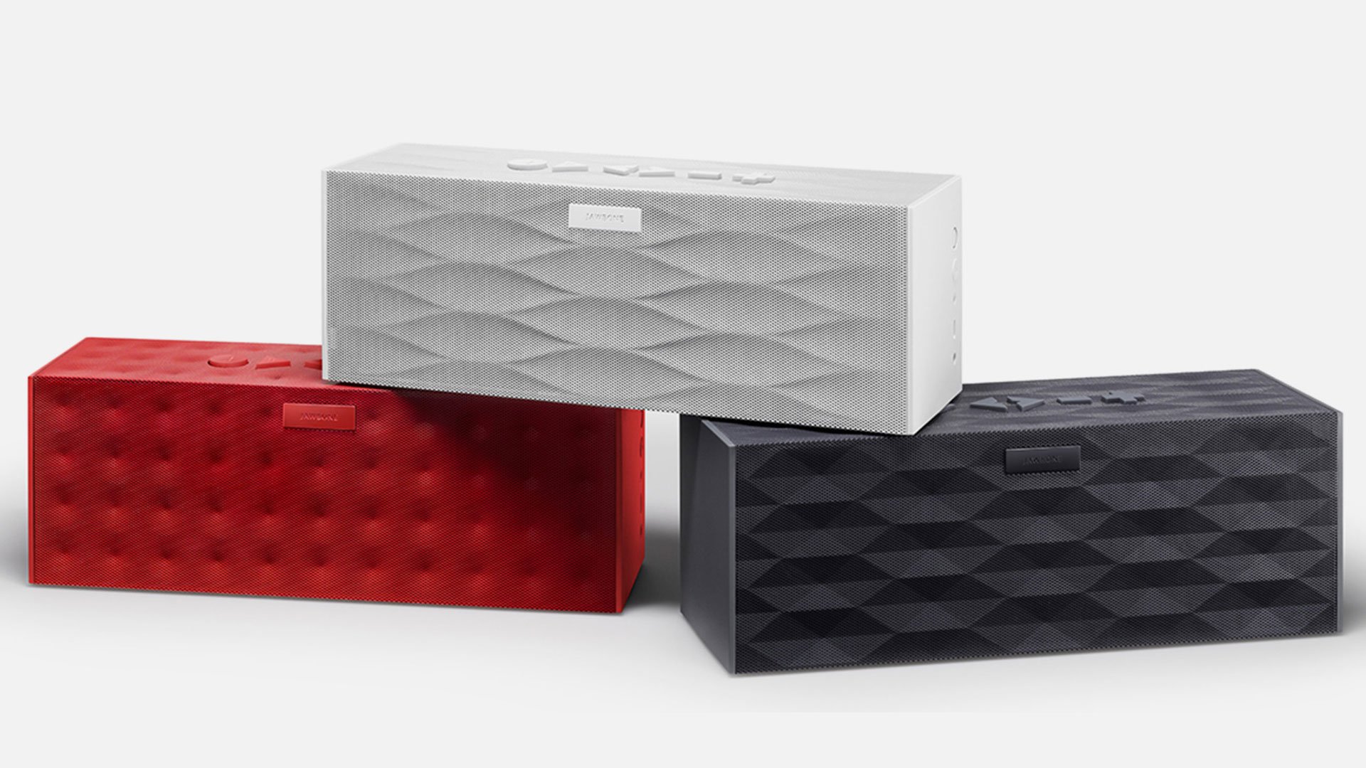 Trio of Big Jambox by Jawbone speakers stacked in red dimpled, white wave and graphite faceted finishes by Yves Behar