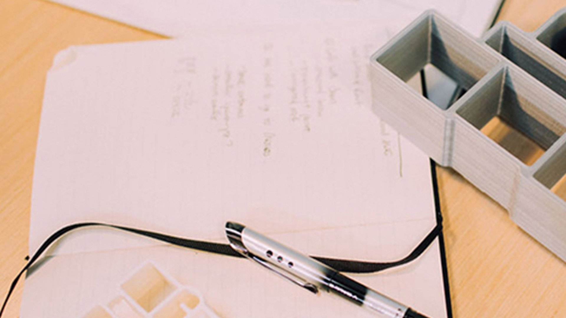 New Story Charity design workspace: wooden blocks of various sizes and a notebook on a beige desk