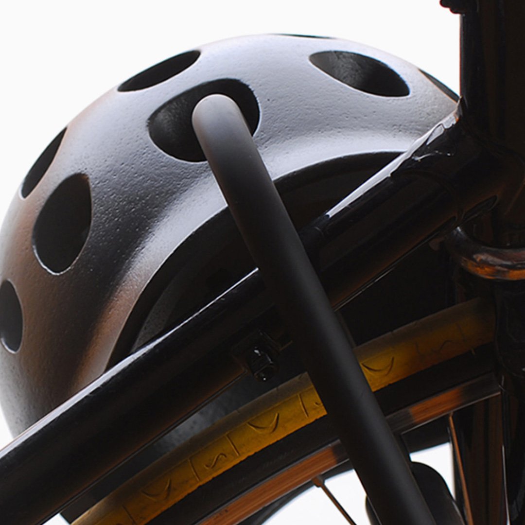 NYC Helmet black and white bicycle helmet with visor mounted on a metal bike rack
