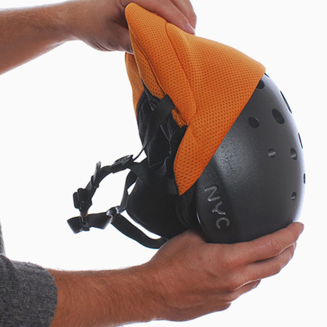NYC Helmet design showing black exterior with orange interior liner and adjustable straps